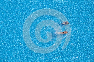 Aerial view of a two girls swimming in the pool