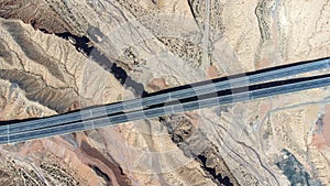 an aerial view of two intersecting roads in the desert mountains