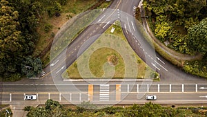 Aerial view of a two-lane road with two exits and a triangle-shaped land in the middle.