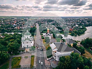 Aerial view of two old churches near river and bridge in small european city