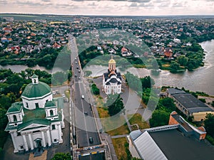 Aerial view of two old churches near river and bridge in small european city