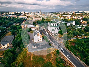 Aerial view of two old churches near river and bridge in small european city