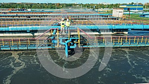 Aerial view of two workers observing a wastewater treatment system