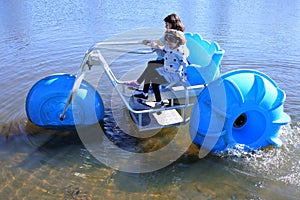 Aerial view of two young girls  riding on a big wheel aqua bike water tricycle