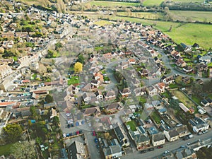 Aerial view of a typical English village which shows expansion of new housing developments around the peripheral.