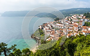 Aerial view of a typical spanish village with a beautiful sandy beach with tourquoise water in Asturias, Spain photo