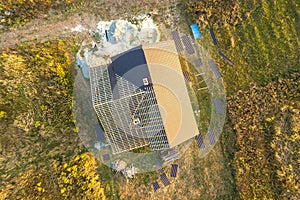 Aerial view of unfinished house with wooden roof structure covered with metal tile sheets under construction