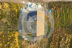 Aerial view of unfinished house with wooden roof structure covered with metal tile sheets under construction