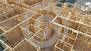 Aerial view of unfinished wooden frame of apartment building ready for mounting roof beams under construction