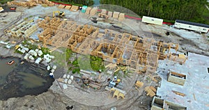 Aerial view of unfinished wooden frame of apartment building ready for mounting roof beams under construction