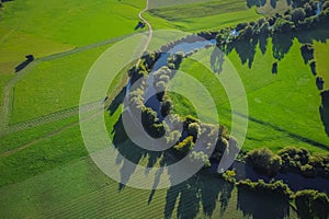 Aerial view of Unica or Unec river on Planinsko polje field in the late summer. Green fields and forests seen from above