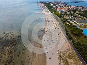Aerial view of unidentifiable people enjoying summer at the beach of Grado in the province of Gorizia at the Northern