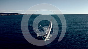 Aerial view of unknown sailboat cruising at sea