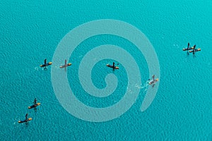 Aerial view of unrecognizable people stand up paddle boarding photo