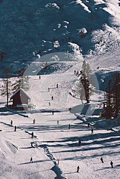 Aerial view of unrecognizable skiers on mountain ski slope