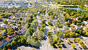 Aerial view of upscale residential area, gated community street real estate with single family homes. Autumn sunny day