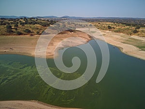 Aerial view of the ValdecaÃ±as reservoir, with green water from the algae and natural lines of the descent of the water. Natural