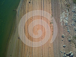 Aerial view of the ValdecaÃ±as reservoir, with green water from the algae and natural lines of the descent of the water. Natural