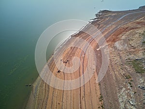 Aerial view of the ValdecaÃ±as reservoir, with green water from the algae and natural lines of the descent of the water. Natural