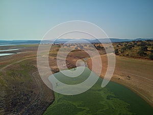 Aerial view of the ValdecaÃ±as reservoir, with green water from the algae and natural lines of the descent of the water. Natural