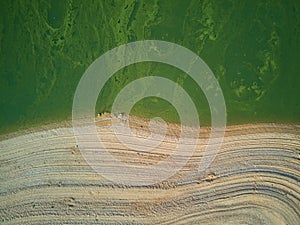 Aerial view of the ValdecaÃ±as reservoir, with green water from the algae and natural lines of the descent of the water. Natural