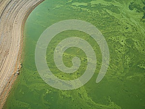 Aerial view of the ValdecaÃ±as reservoir, with green water from the algae and natural lines of the descent of the water. Natural