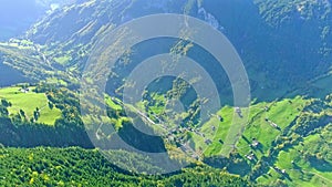 Aerial view of the valley between the mountains covered with the green forest
