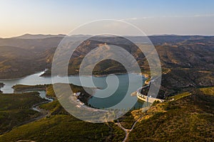 Aerial view of the valley, olive fields and Embalse de Forata reservoir during sunset. Summer in Spain