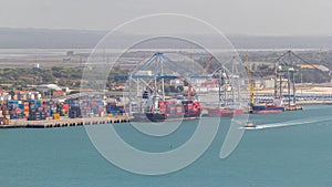 Aerial view of various containers stored in the container terminal near water timelapse, Setubal, Portugal