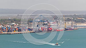 Aerial view of various containers stored in the container terminal near water timelapse, Setubal, Portugal