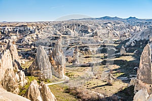 Aerial view of various rocks and Cave hotel in the valley of Goreme against blue sky, built in rock formation in national park