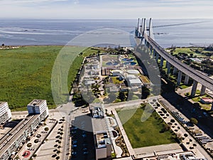 Aerial view of Vasco da Gama bridge crossing Tagus river and an industry water plant in foreground, Oriente district, Lisbon,