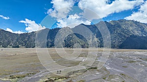 An aerial view of a vast plain with mountains in the distance