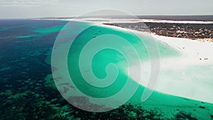 Aerial View of a Vast Turquoise Sea Meeting a Sandy Beach During Daytime