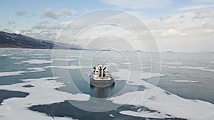 Aerial view of a vehicle with rubber air cushion on Siberian lake Baikal in winter. Clip. Rear view of a khivus boat