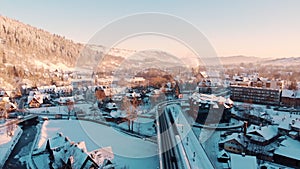 Aerial view Of Vehicles Moving On A Bridge With Snow-Covered Houses On Sides