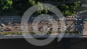 Aerial view of the vehicular intersection, traffic at peak hour with cars on the road, fly under trees