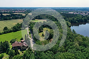 Aerial view from a vertical perspective of a house with big garden at the edge of a forest with a meadow in front of it