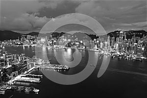 Aerial view of Victoria Harbor of Hong Kong city at night in black and white