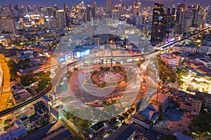 Aerial view of Victory Monument with car light trails on busy street road. Roundabout in Bangkok Downtown Skyline. Thailand.