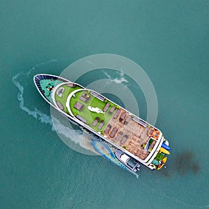 Aerial view of a Vietnamese luxury boat in Halong bay when oil spill in the sea. Ecological background. Environmental pollution