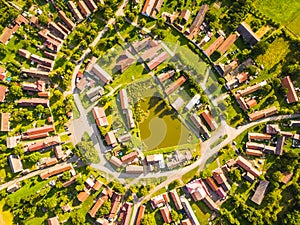 Aerial view of village centre with pond in summer