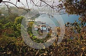 Aerial view on village coast along lake Atitlan through trees, San Juan la Laguna, Guatemala photo
