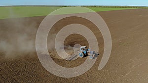 Aerial view vintage old tractor plowing soil in farm field and preparing land for sowing crops