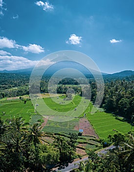 Aerial view of volcano and beautiful fields landscape during sunny summer day in Bali