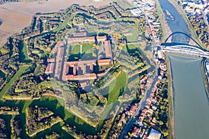 Aerial view of walls and bastions of modern six-star hexagon shaped fort Cittadella of Alessandria on winding river Tanaro