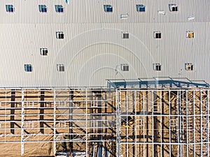 Aerial view of warehouse construction from steel metal structure. Frame of modern hangar or factory construction site.