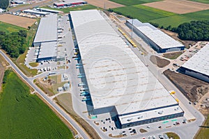 Aerial view of a warehouse of goods. Logistic warehouse buildings and many trucks loading goods