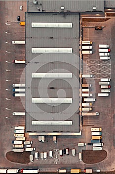 Aerial view of a warehouse with goods. Logistics center in the industrial zone of the city, many trucks are waiting for loading in