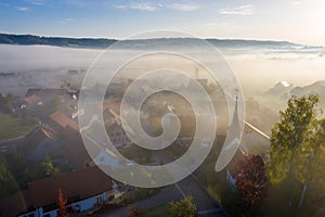 Aerial view of warm sunrise in a foggy Swiss tourist medieval town, near castle Schloss Schwandegg, Waltalinge, Stammheim.